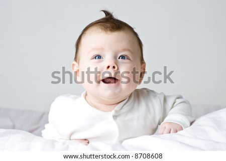 Baby infant girl on white cloth. White background.