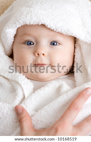 A cute baby wrapped in a towel.