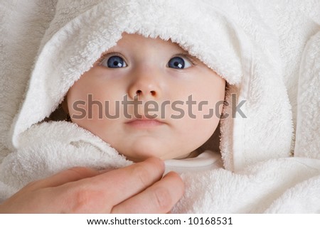 A cute baby wrapped in a towel.