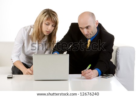 A businessman helping a young woman set up her laptop computer