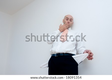 Man in business dress clothes with empty pockets pulled out.