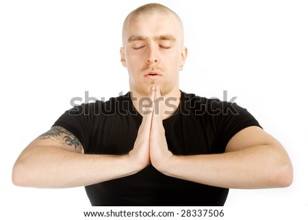 Isolated man with tatoo on his right arm in black shirt in deep meditation on white background