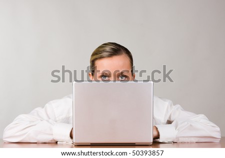 Portrait of partially obscured young businesswoman with laptop computer, white studio background.
