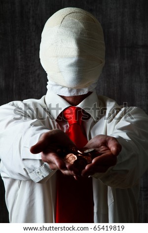 Portrait of anonymous businessman with bandaged face holding pile of coins, dark background.