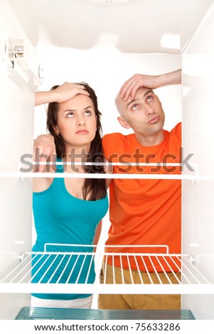 Man and woman looking into an empty refrigerator.