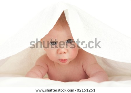 Portrait of a cute little baby boy covered with a blanket on his head. Image isolated on white studio background.