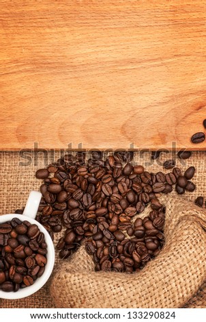 scattered grains of coffee, cup with grains and wooden board