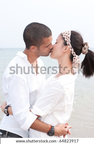 stock photo : african man and asian woman lover on the beach