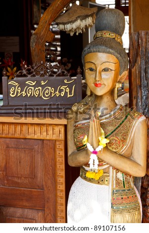 You\'re welcome in thai word on wood piece with Thai woman sculpture for Sawasdee welcome of thailand