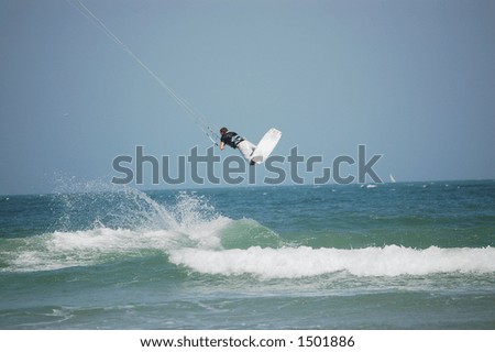 A kitesurfer launches into the air off a breaker on Ponce Inlet Beach, Florida