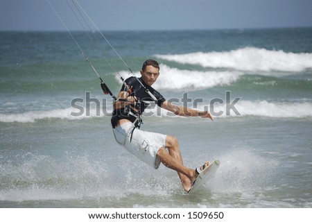 A kitesurfer concentrates on precise balance as he approaches the beach at Ponce Inlet Beach, Florida