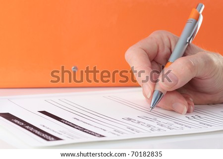 Orange Themed Pen in Hand Completing Form