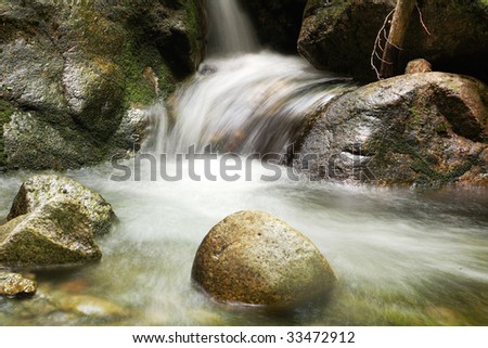 Water of a mountain stream, running on rocks