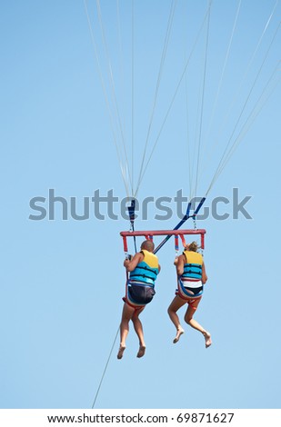 Man and woman in the air para sailing