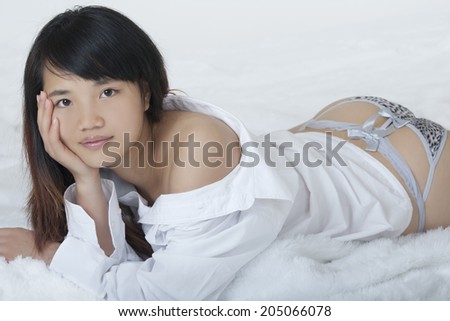Beautiful and sexy Chinese woman wearing a white shirt isolated on a white background