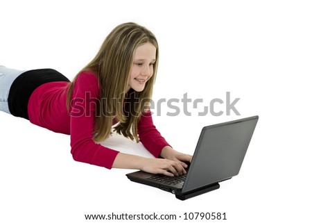 Child laying on a white background working on laptop computer