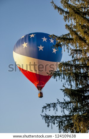 Balloon lift off near a pine tree