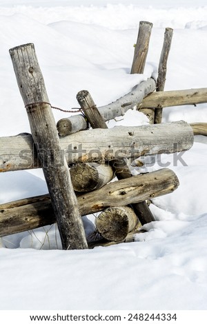 Rustic wilderness fence post in the snow