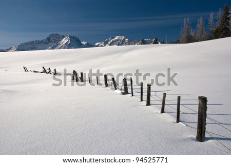 Barbed Wire fence covered with snow in an Idaho mountain scene