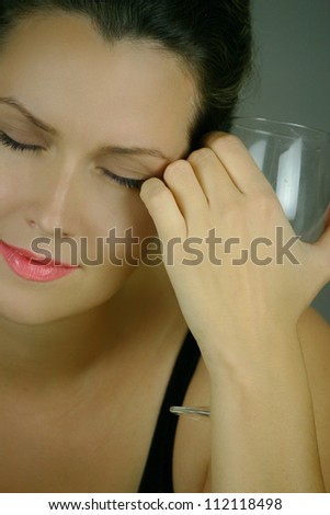 Beautiful woman drinking wine and dreaming with closed eyes