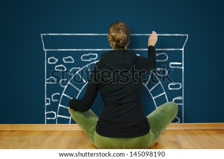 A woman is sitting on an empty floor in an empty apartment, and draws on the wall of fire.
