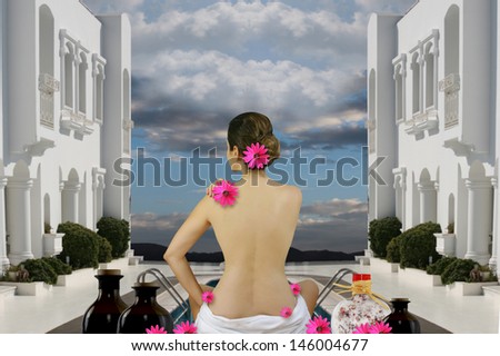 Spa wellness woman sitting with a bare back in a towel in a white hotel and relax