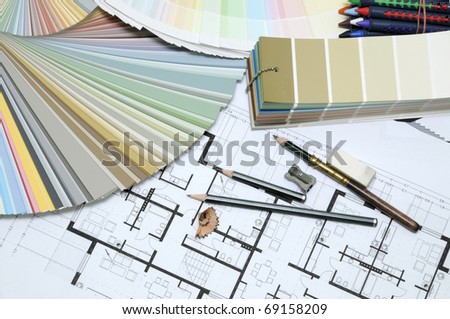 Architect's and Designer's desk during work. With technical drawing, color sample catalog, pencils, wax crayons and other tools.