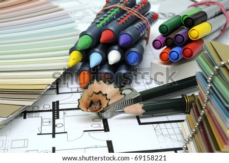 Architect\'s and Designer\'s desk during work. With technical drawing, color sample catalog, pencils, wax crayons and other tools.