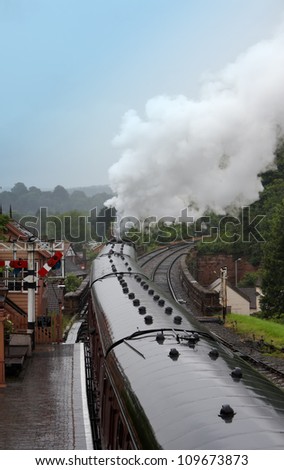 A steam train leaving  the station in yorkshire