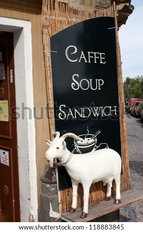 A cafe sign with a ornate goat