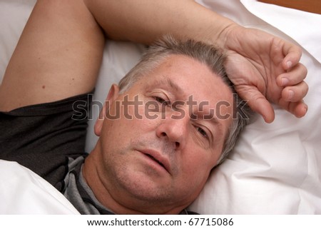 A Mature man waking up in bed