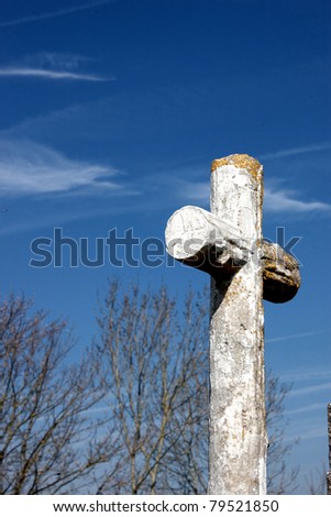 A white cross on a grave in a grave yard