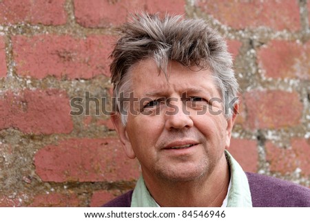 Mature man portrait with red brick wall background