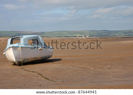 A boat on the estuary with the tide out