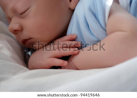 A one week old baby boy asleep