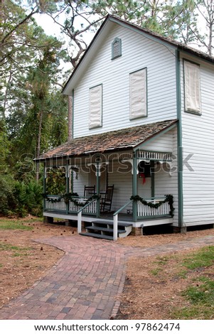 An American house in the woods with the porch decorated with christmas garland