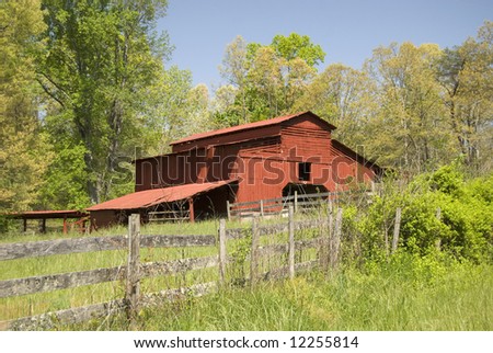 Red wooden barn behind an old country fence