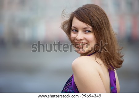 Young beautiful brunette girl in a purple dress