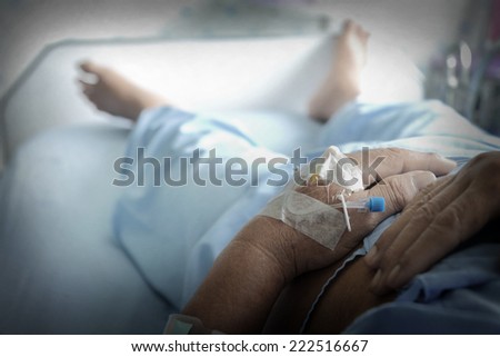 Close up of patient\'s hand with iv solution set.