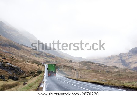 A truck drives through Glencoe in the Scottish Highlands in heavy mist and rain.