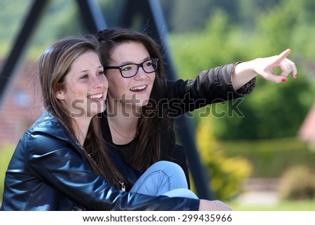 Two friends showing a direction with the hand