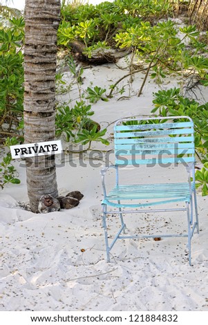 Private sign and old chair indicating a private property access coming from the beach, Eleuthera, Bahamas, Caribbean