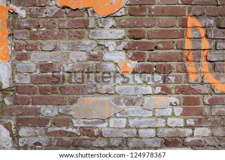 Grunge red brick wall texture with fluorescent graffiti