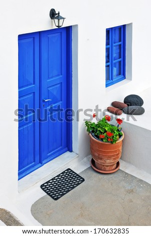 White house with blue door and window in Oia, Santorini, Cyclades, Greece