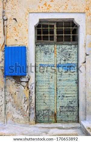 Weathered door and electrical box of an abandoned workshop in Pyrgos, Santorini, Cyclades, Greece