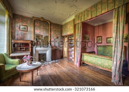 FRANCE - SEPTEMBER 26, 2015: Dilapidated luxurious bedroom in an abandoned castle, somewhere in France.