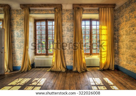 Windows with yellow curtains in an abandoned castle, HDR processing