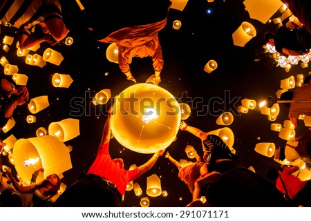 CHIANG MAI, THAILAND - OCTOBER 20, 2010: Group of Thai people launch a sky lantern on the night of the annual festival known as Yee Peng (Yi Peng).