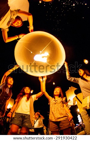 CHIANG MAI, THAILAND - OCTOBER 24, 2009: Group of Thai people launch a sky lantern on the night of the annual festival known as Yee Peng (Yi Peng).