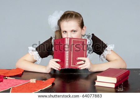 Studio shot of a girl stylized like a Soviet Union student reading a book